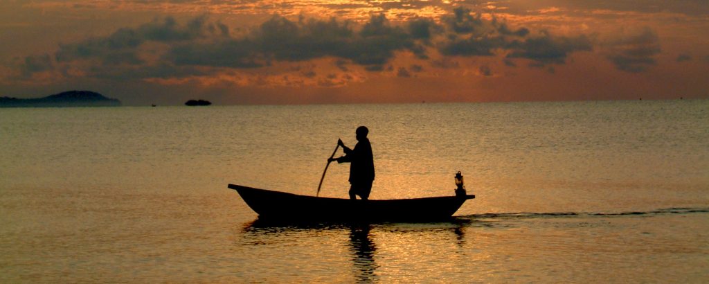 A fisherman in his canoe head home for the night in Malawi