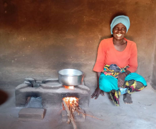 A happy householder with her new cookstove in Malawi