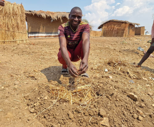 A happy farmer with his tree seedling and new basin in Malawi