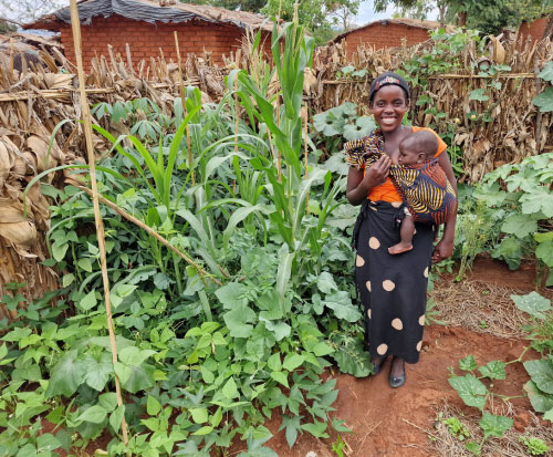 Memory is growing vegetables near her house in Malawi