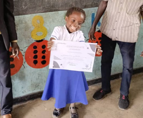 A happy learner graduating from pre-school in Malawi