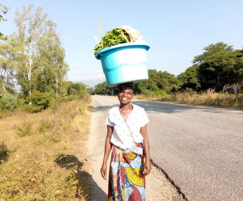 Chikondi is impressive carrying the vegetables on her head
