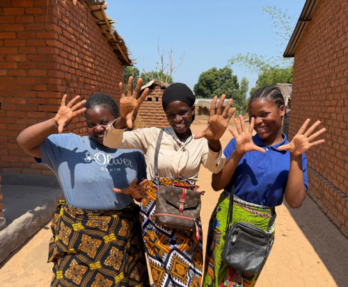 Three of Ripple Africa's employees smiling and waving