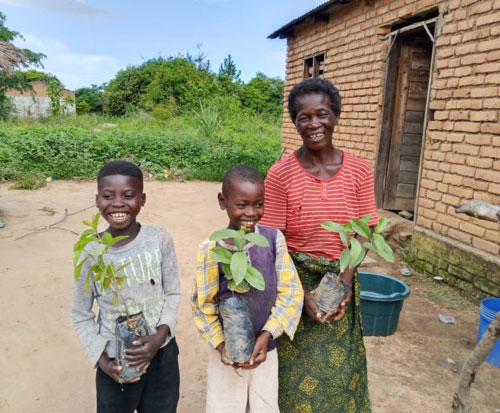 Grades and her grandsons holding fruit trees from their growing the future club