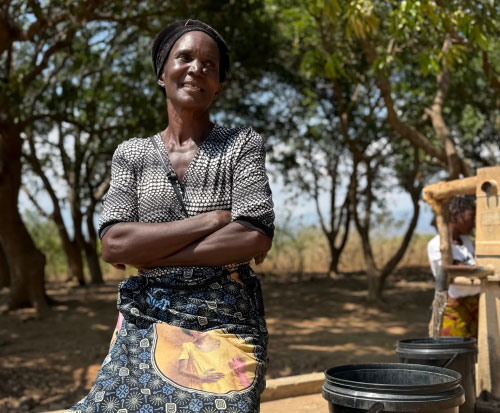 Beatrice sat in front of the recently repaired borehole