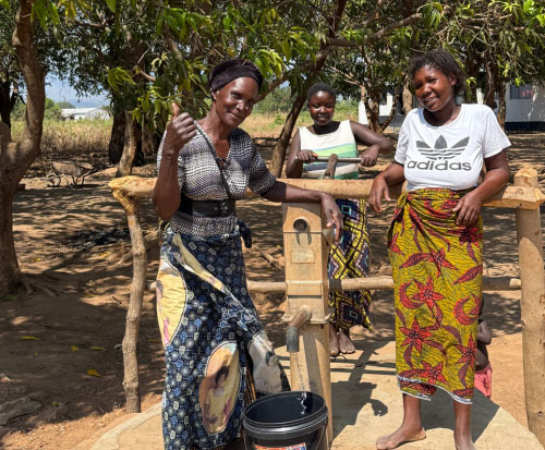 Beatrice with her friends using their repaired borehole