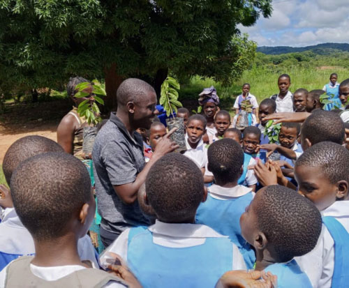 Maston explaining fruit tree seedlings to students