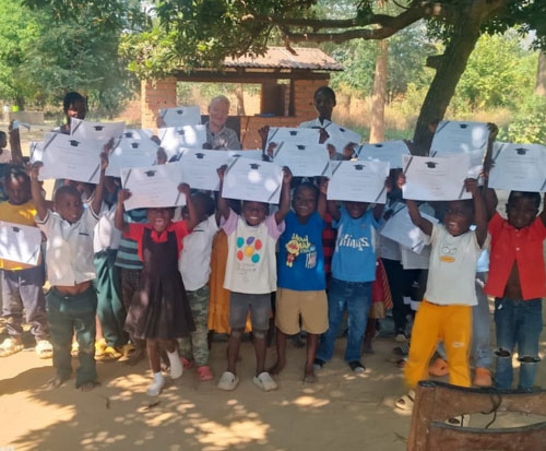 Preschool class holding up their graduation certificates