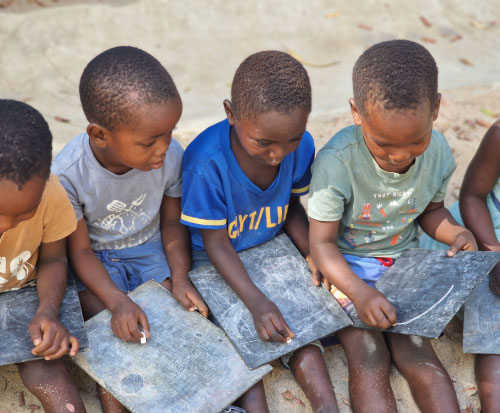 Children sat together using blackboards